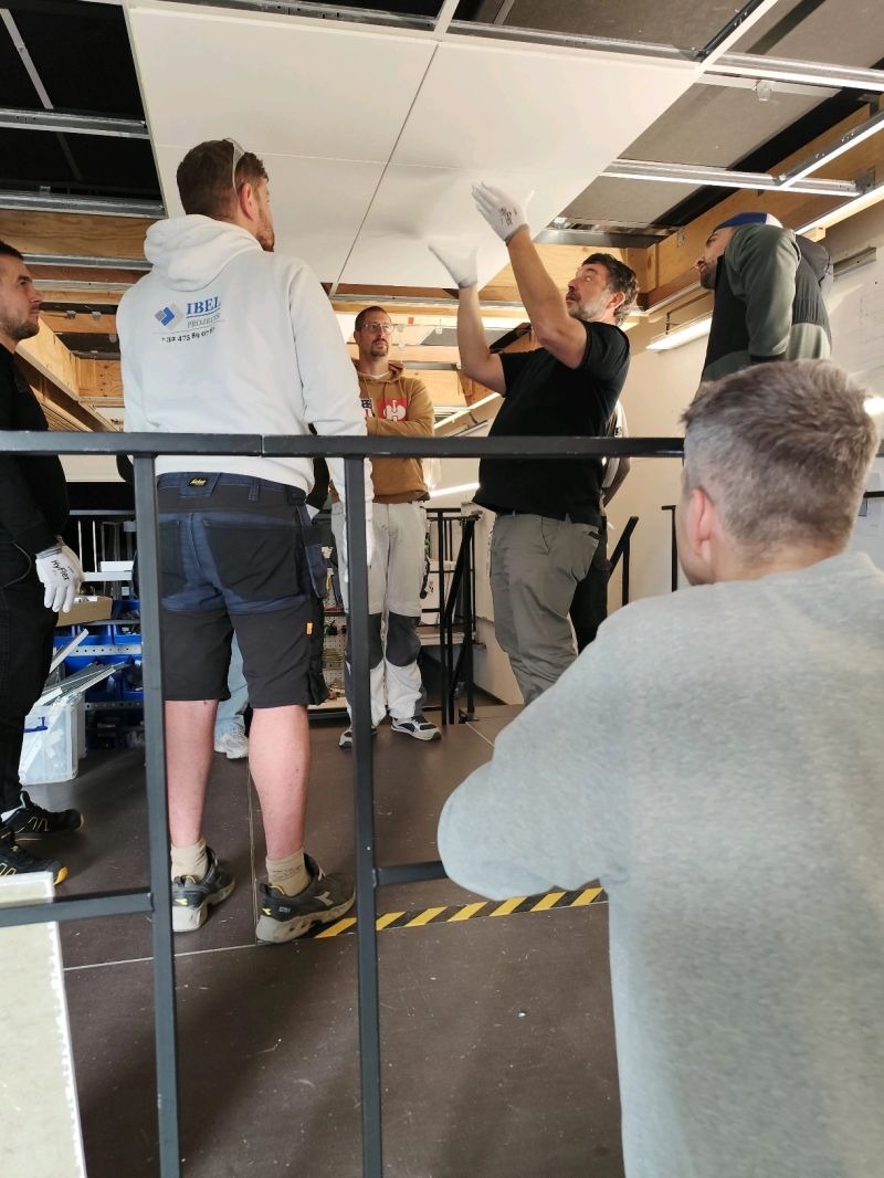 Demonstration du geste de pose de dalles de plafond acoustique Rockfon avec des artisans